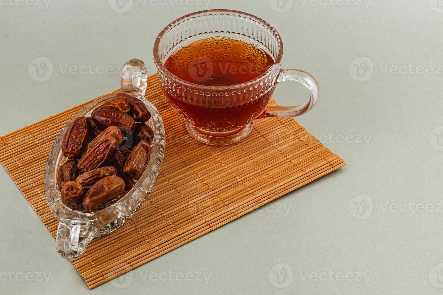 Tea served with delicious dates on a bamboo mat photo