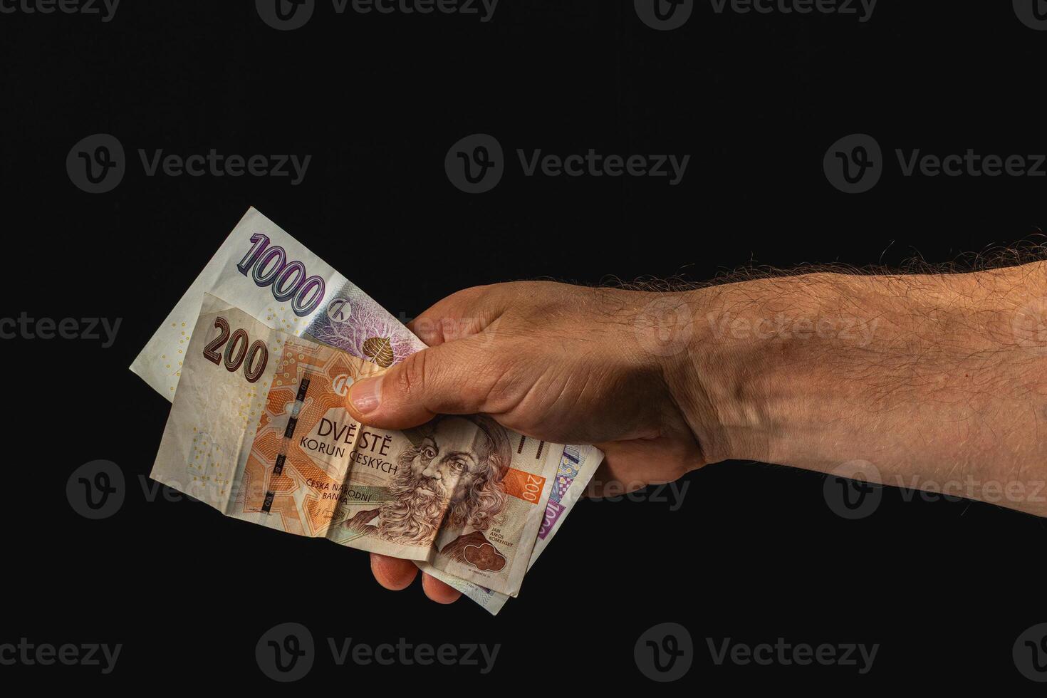 Hand holding various banknotes against dark background photo