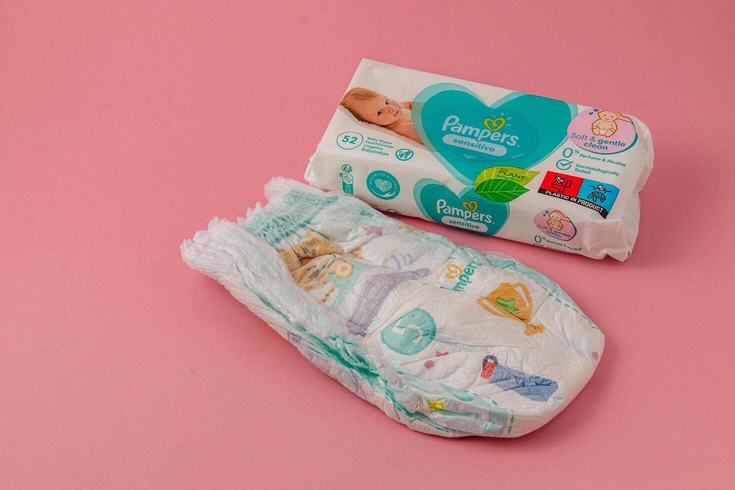 Lviv Ukraine 05.06.25 Baby diaper packaging displayed on soft pink background photo
