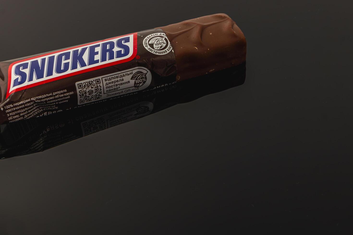 Lviv Ukraine 05.06.25 Chocolate bar on a reflective surface in a dim light setting photo