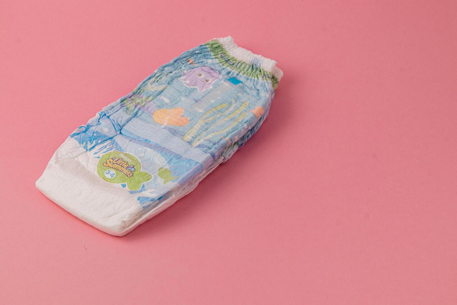 Lviv Ukraine 05.06.25 Colorful baby diaper on a pink background ready for use photo
