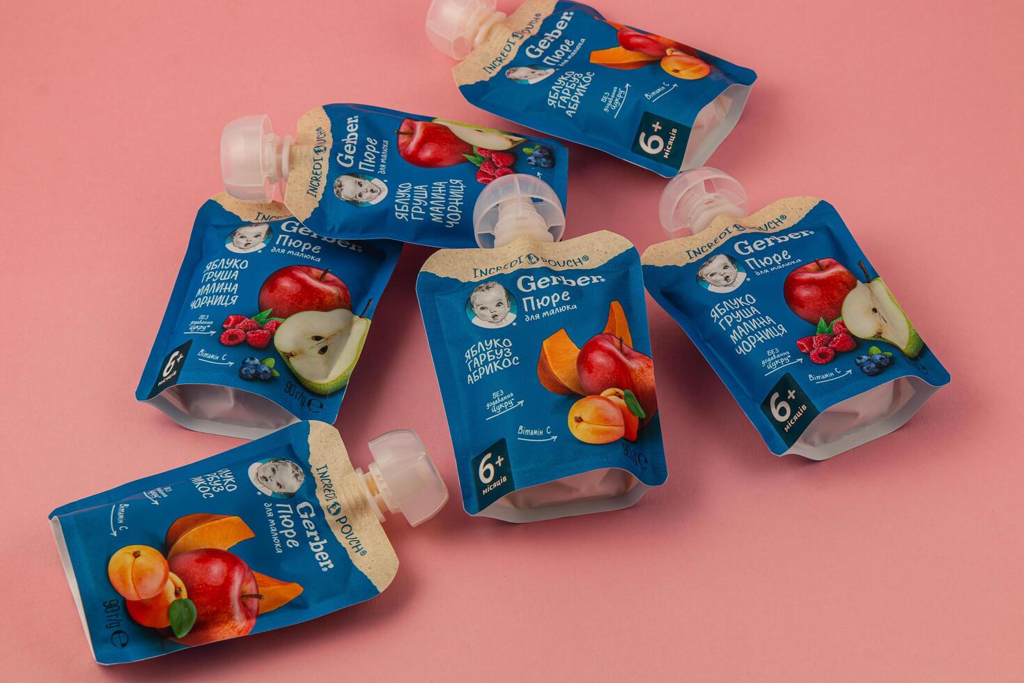 Lviv Ukraine 05.06.25 Fruit puree pouches in various flavors on pink background photo