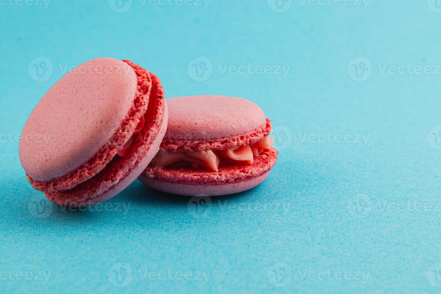 Delicate pink macarons on bright turquoise background photo