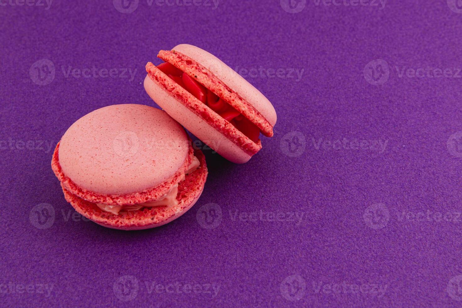 Pink macarons arranged on a vibrant purple background photo