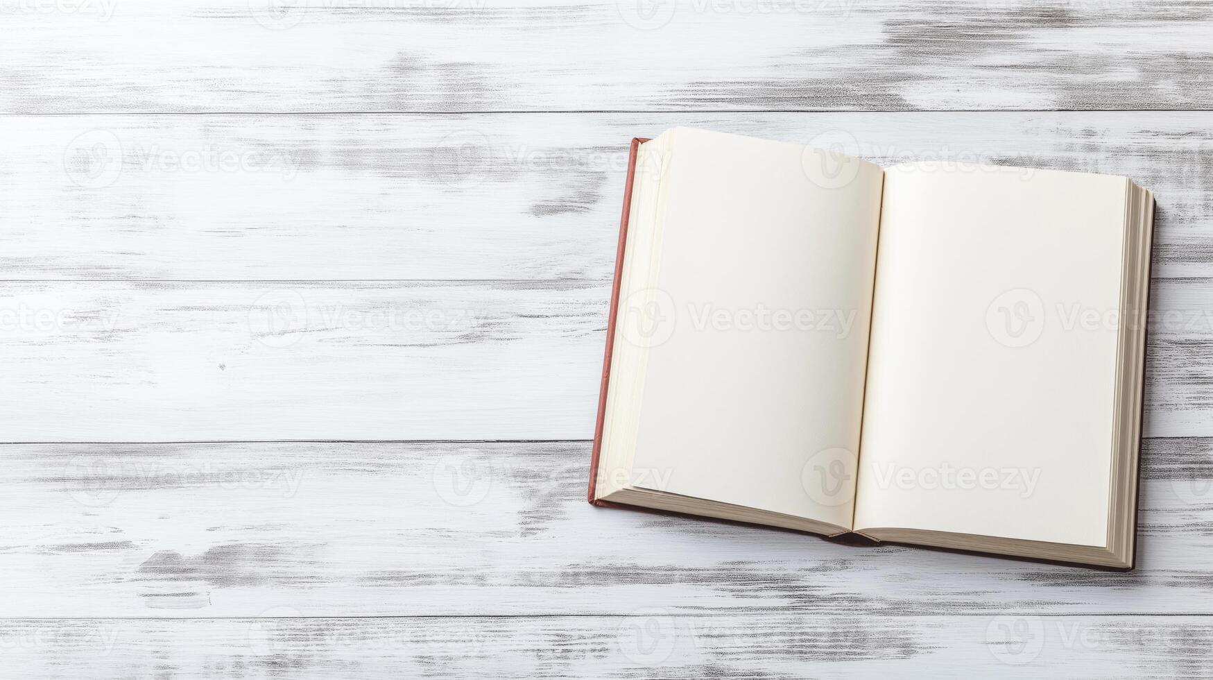 open book or magazine lying on a white wooden surface. The book appears to be blank photo
