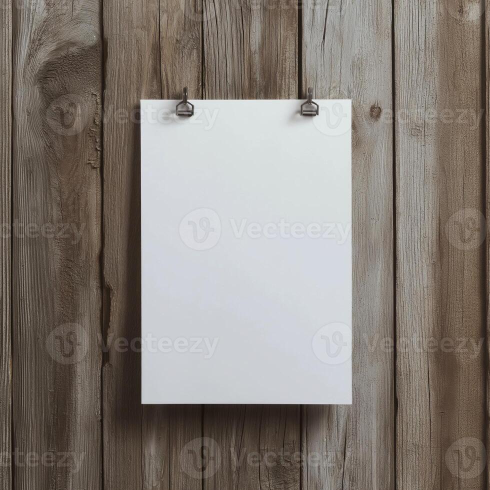 blank white paper hanging on a wooden wall. The paper is hanging from a metal hook on the wall, which is attached to the wooden planks photo