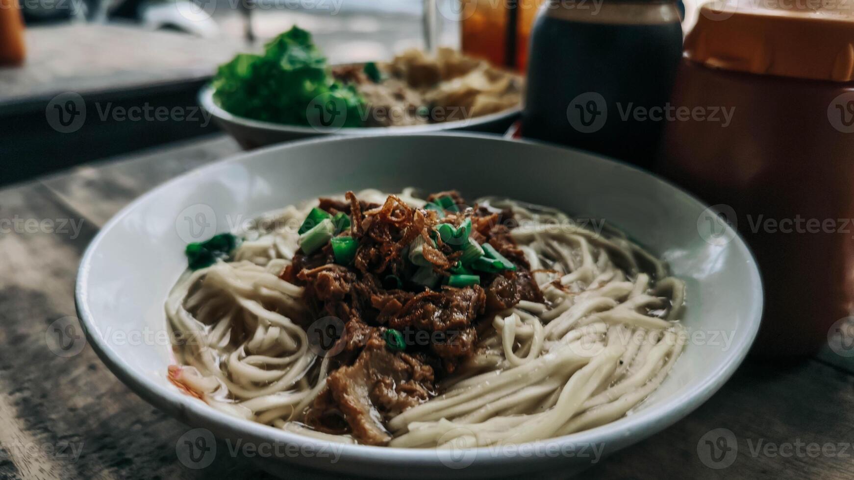 A Bowl of Savory Cwie Mie Topped with Chicken photo