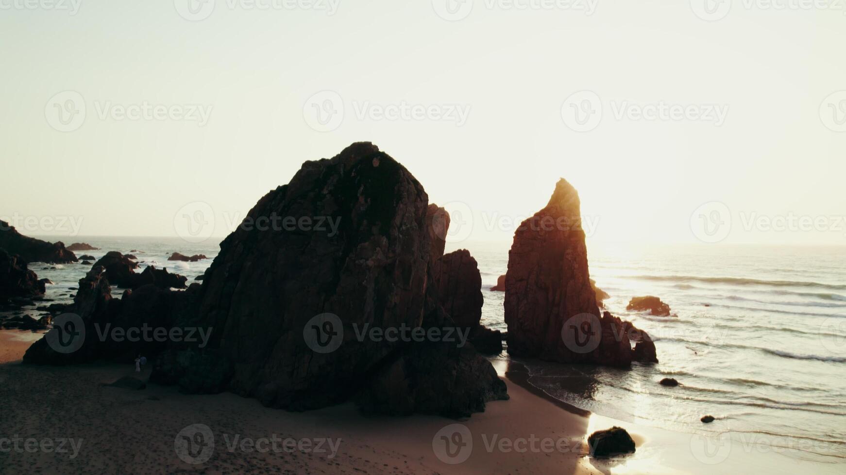 Sharp peaks of rocks on the seashore washed by sea waves. Drone at sunset - sunset photo