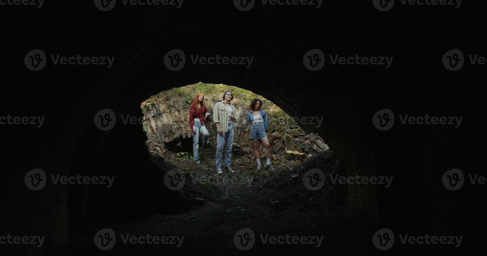 Friends are standing near the ruins. They are looking at the destroyed building. View from the building basement photo