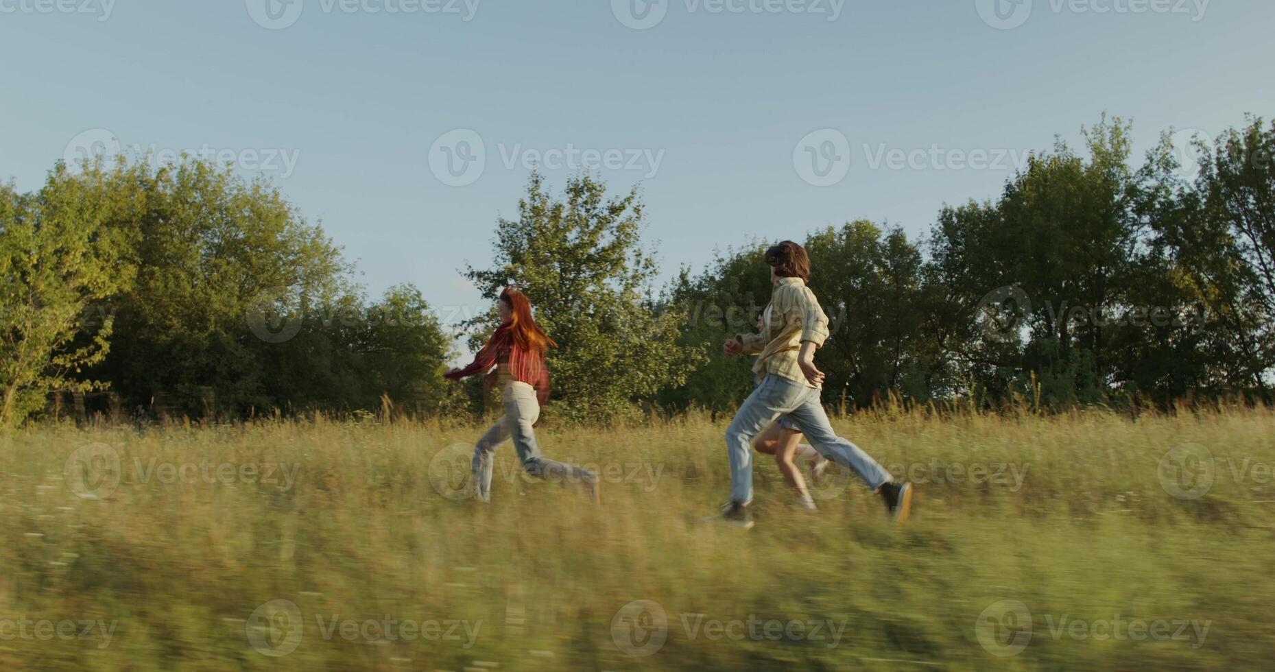 Three young friends are having fun and running around the field on a sunny day. photo