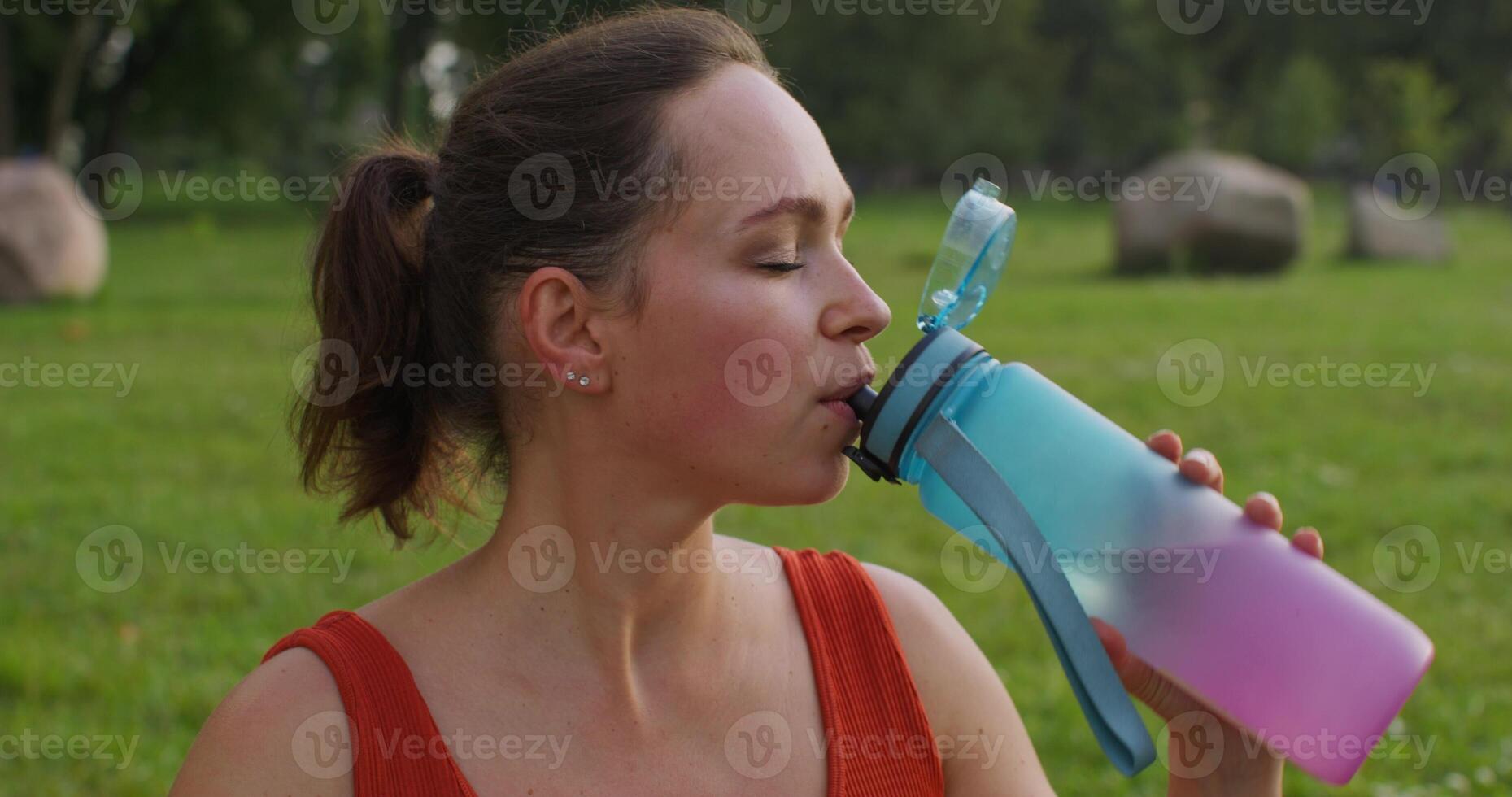 Woman drinking water in the park photo