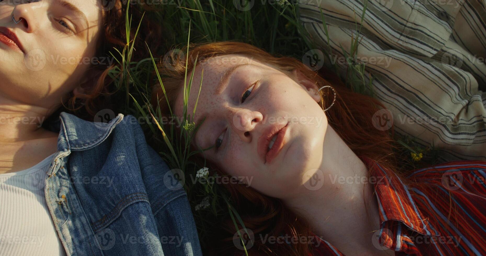 young people are talking lying on the grass in a field. They look tired and happy. View from above. photo