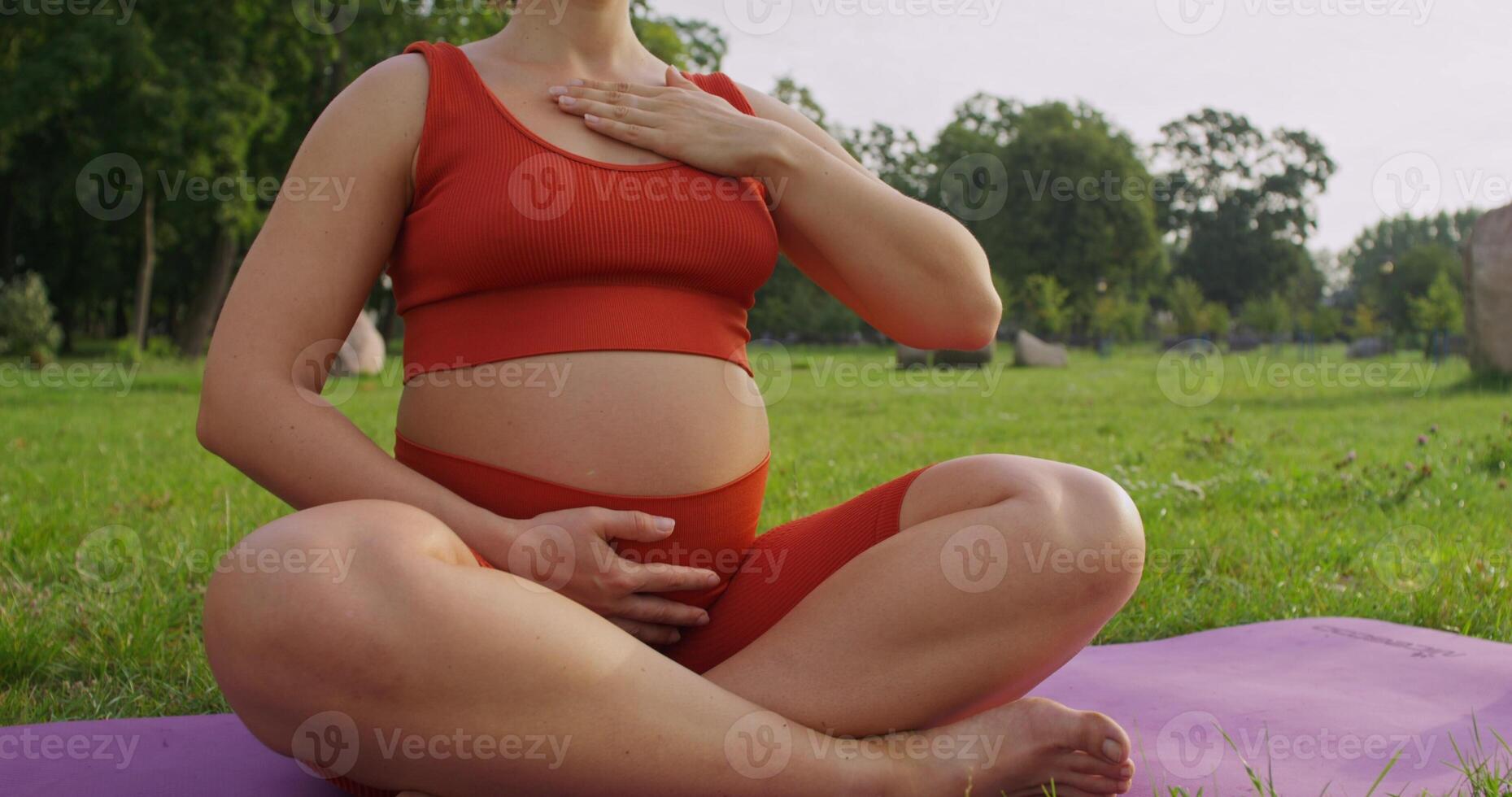 Pregnant woman outdoors in a peaceful green park, summer day, pilates photo