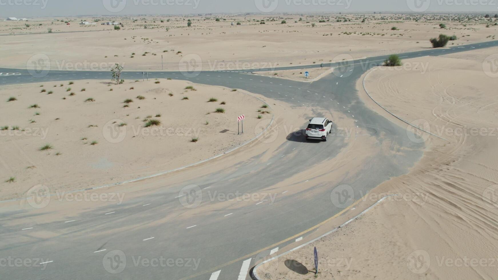 The car is driving along the ring road among the sand dunes in the desert. Drone view while driving photo
