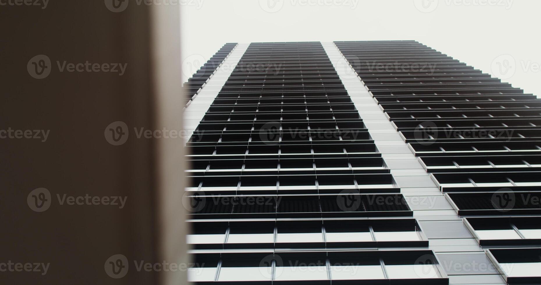 Facade of a high-rise office building with large panoramic windows. Business Quarter, no people on . The gray building of the business center. Skyscraper, view from below. in 4k, red komodo photo
