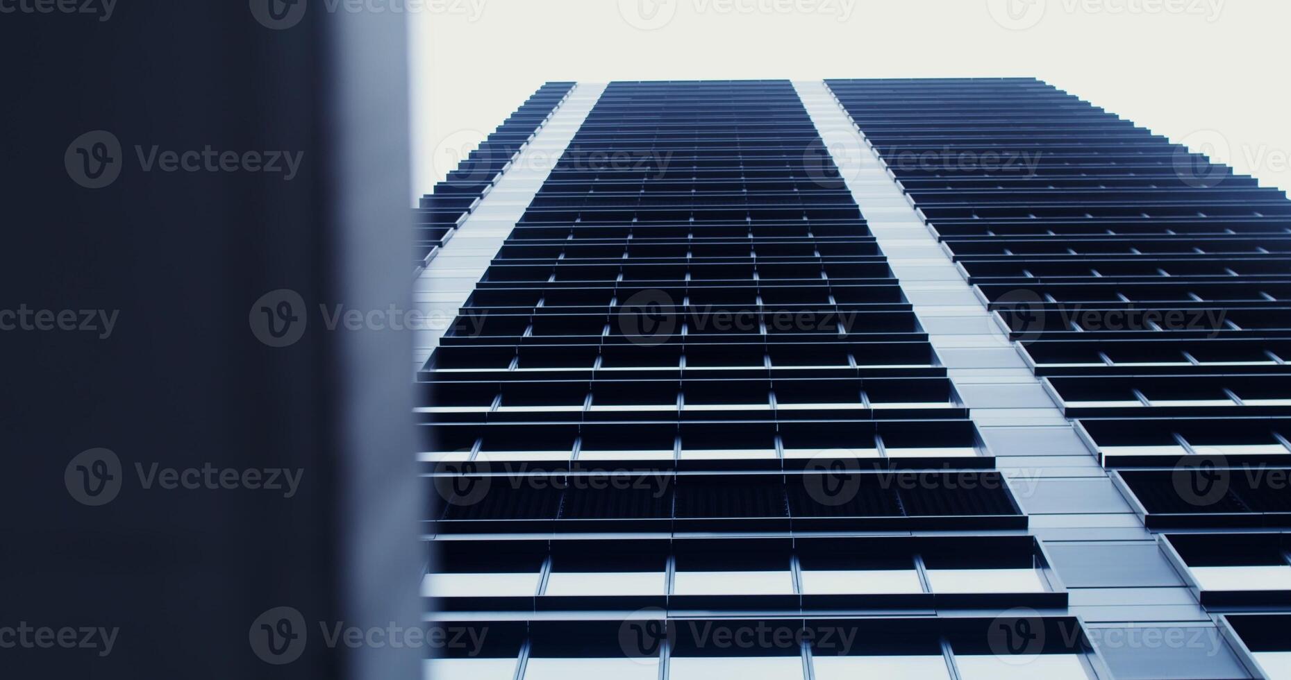 Facade of a high-rise office building with large panoramic windows. Business Quarter, no people on . The gray building of the business center. Skyscraper, view from below. photo