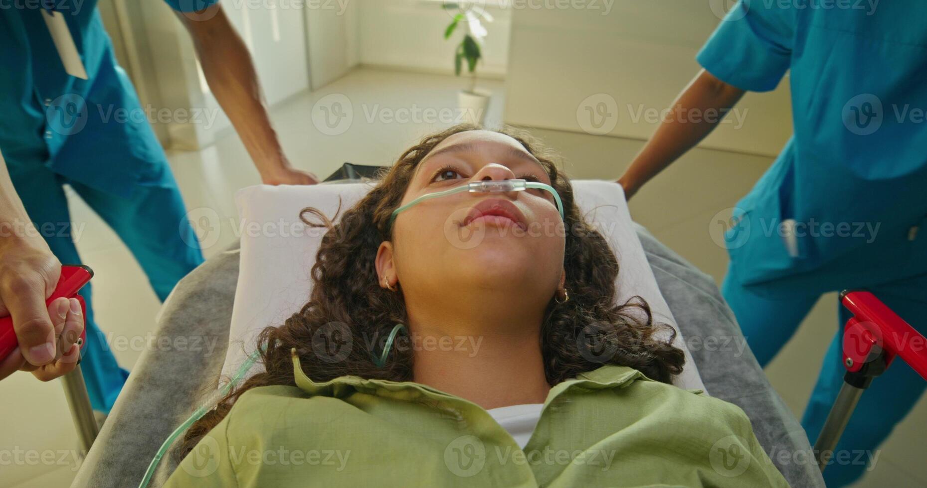 Medics are taking a woman on a gurney along the hospital corridor. The oxygen tube photo