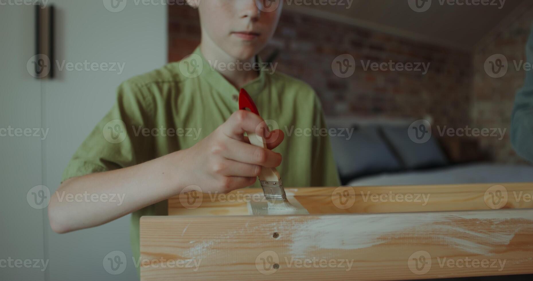 A father and son of European appearance paint a rack using brushes, sitting in a home interior, they smile and talk - appearance photo