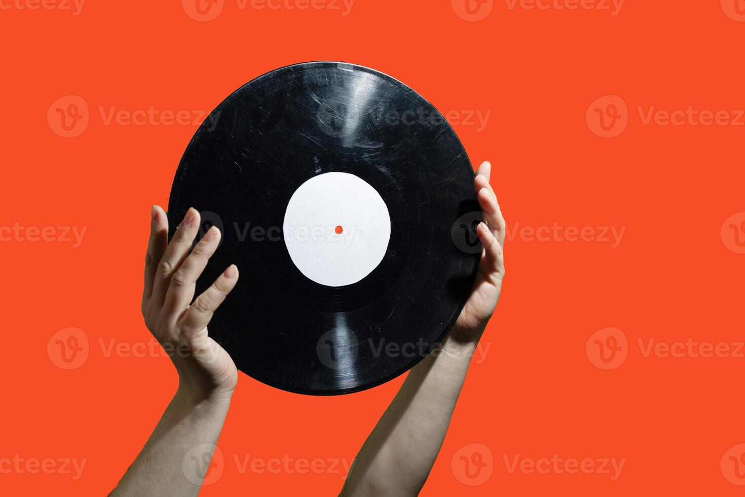 Two hands firmly grasping a vinyl record set against a lively and vibrant background scene photo