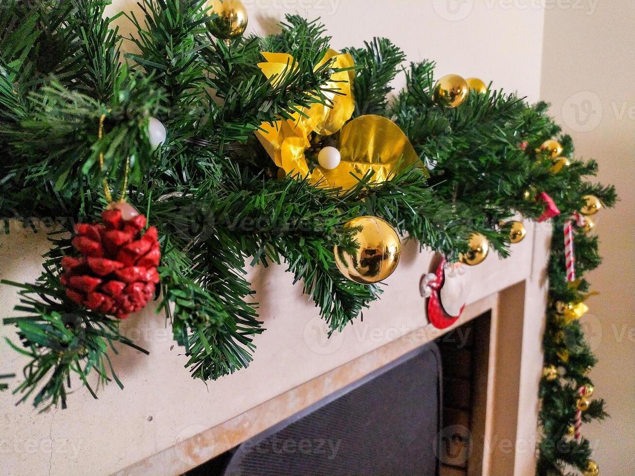 Festive Christmas garland with gold ornaments and yellow bows adorns a fireplace mantel. Perfect for holiday cards, websites, or advertisements, this image evokes warmth and cheer. photo