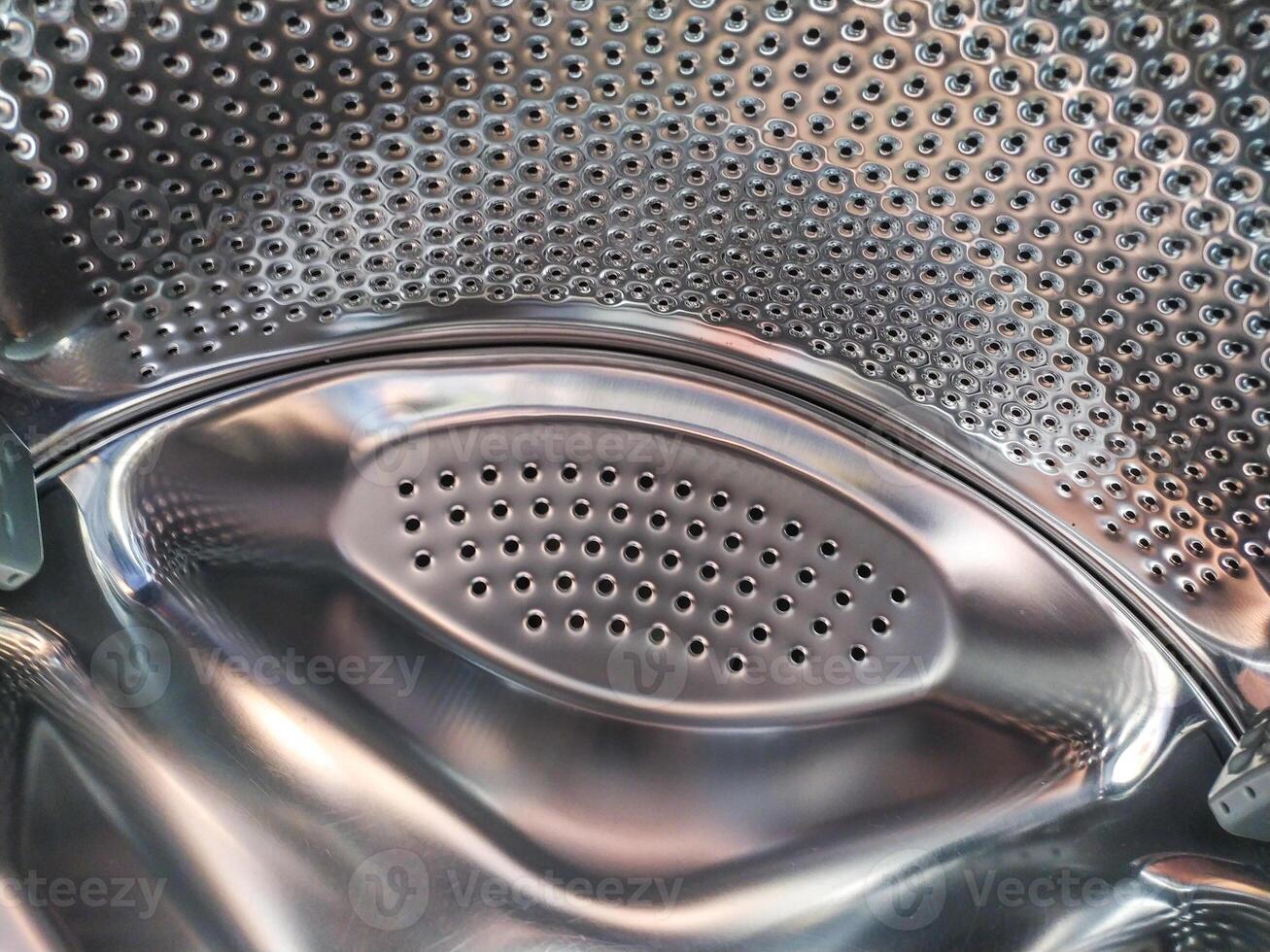 Abstract, shiny interior of a metal drum. Represents cleanliness, routine, or technological precision. Use for concepts of cycles, hygiene, or domesticity. photo