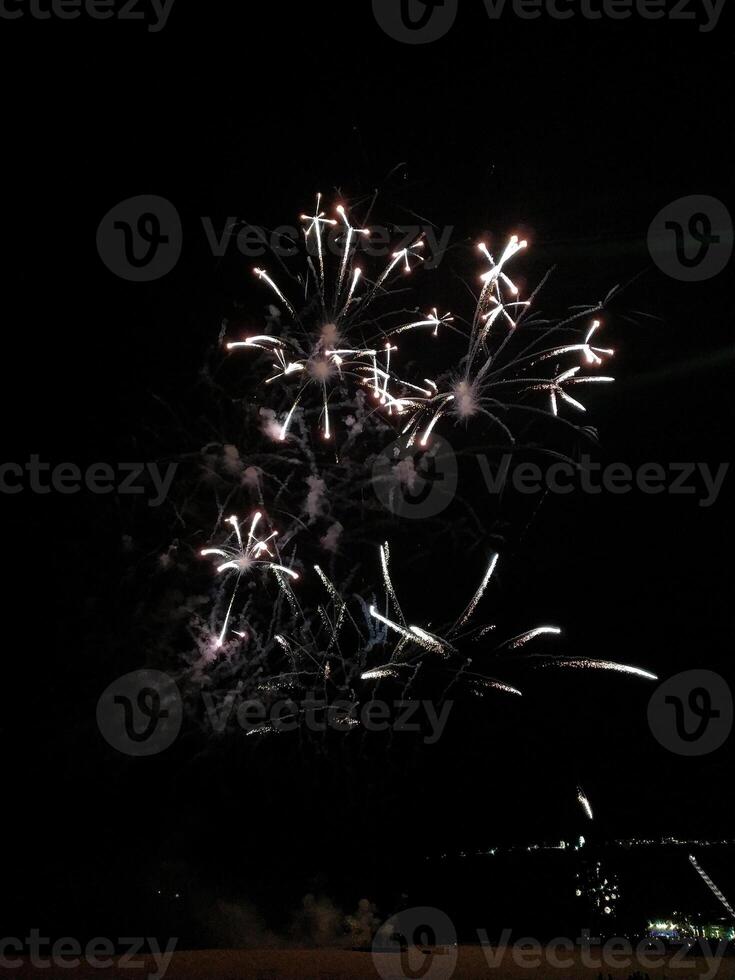 Stunning nighttime fireworks display explodes across a dark sky, creating a breathtaking spectacle of light and color. Perfect for celebratory themes, holiday imagery, or event promotions. photo