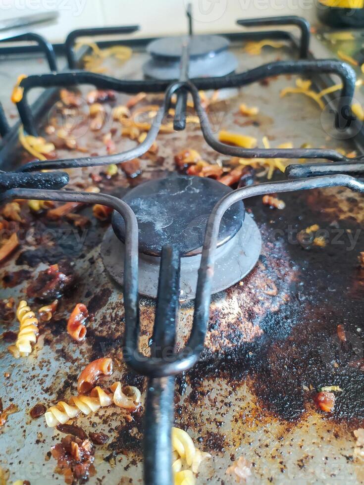 Closeup view of a dirty stovetop. Shows neglected household chores, mess, and the aftermath of cooking. Illustrates domestic reality, imperfection, and daily life. photo
