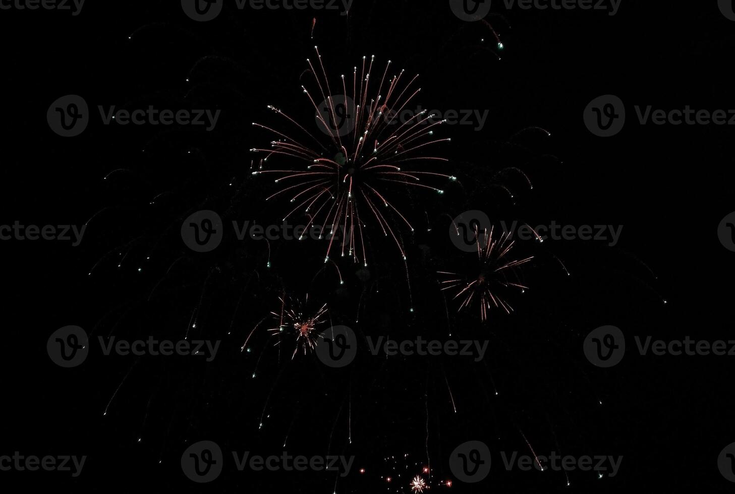 Stunning fireworks display against a deep black night sky. Red and teal bursts illuminate the darkness, creating a vibrant and festive scene perfect for celebrations, holidays, and event promotion. photo