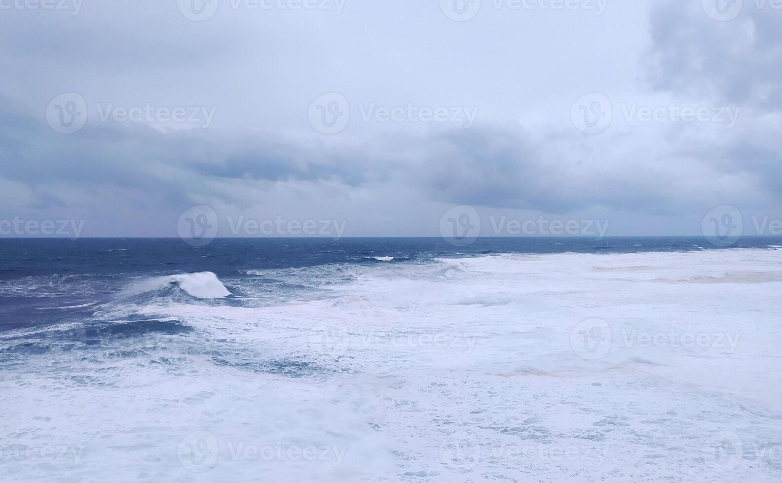Dramatic seascape featuring powerful waves under a stormy sky. Evokes strength, resilience, or challenge. Ideal for themes like nature, weather, or overcoming obstacles. photo