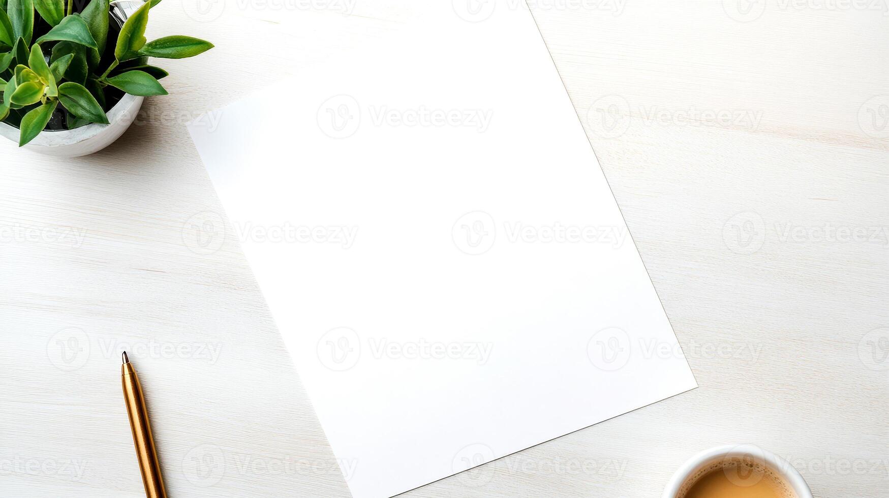A pure white sheet lies on a textured light wooden surface beside a small green plant and a cup of coffee, creating a serene workspace setting photo