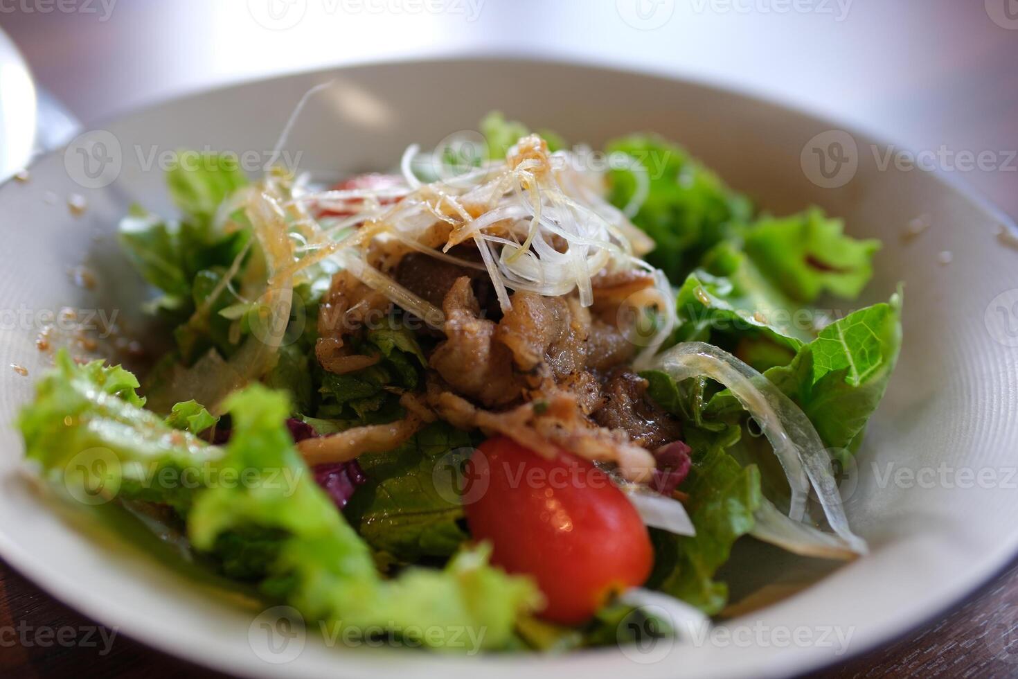 Beef Salad warm salad with veal, lettuce mix and grilled vegetables - mushrooms, eggplant, zucchini, tomatoes in ceramic plate on wooden table. Selective focus photo
