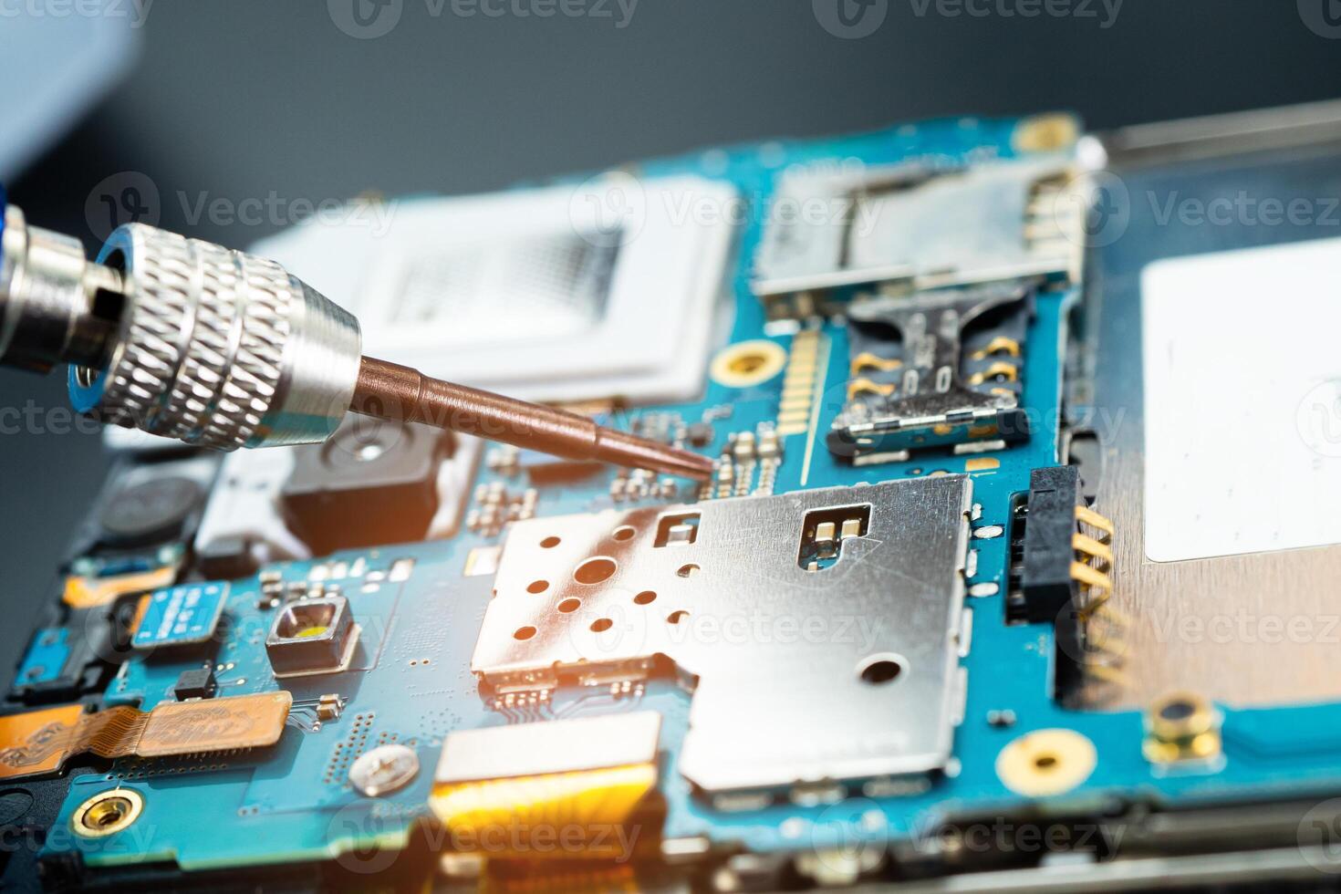Technician repairing inside of mobile phone by soldering iron. Integrated Circuit. the concept of data, photo