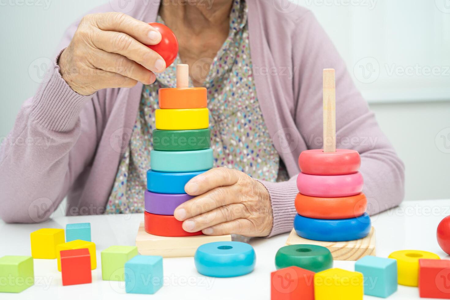 Asian elderly woman patient suffering from dementia learn practical motor skills rehabilitation. photo