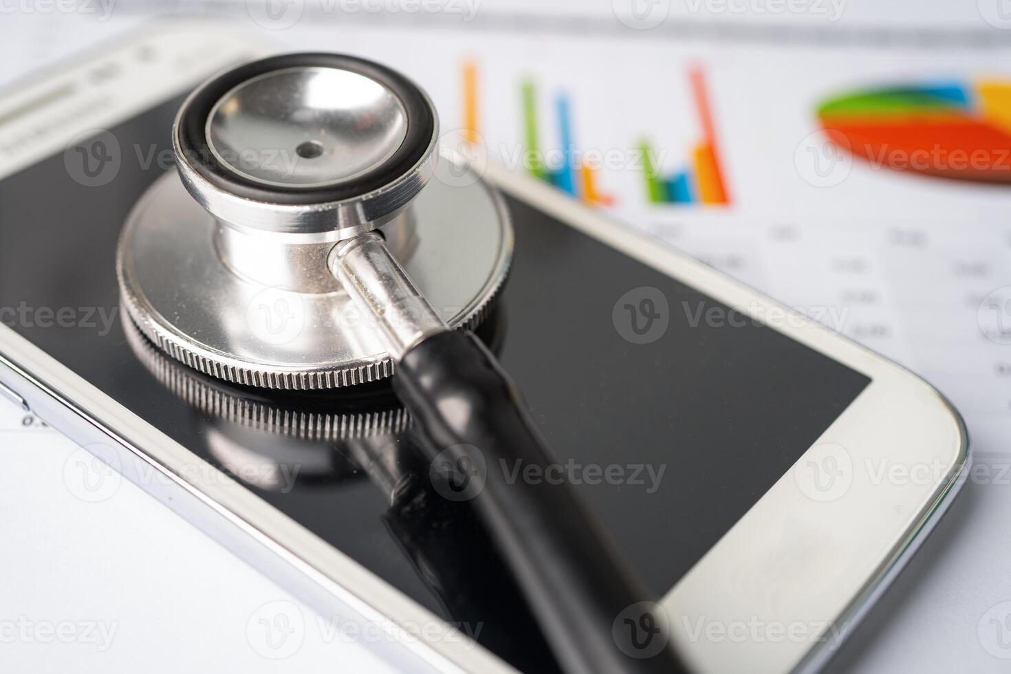 Stethoscope with mobile phone on graph paper, Finance, Account, Statistics, Investment, Analytic research photo