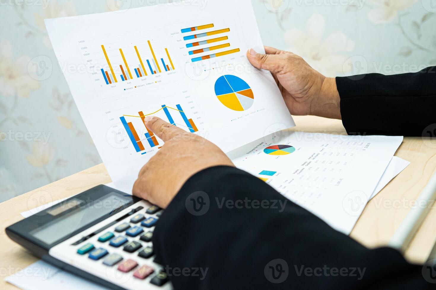 accountant working and analyzing financial reports project accounting with chart graph and calculator in office, finance photo