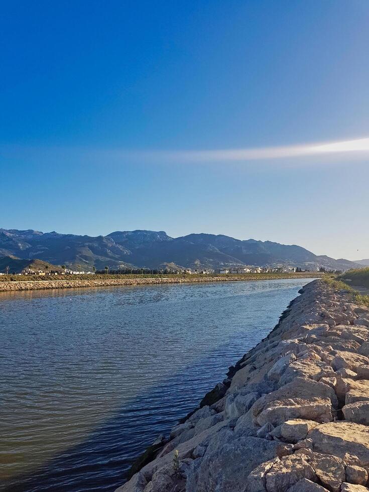 A quiet valley showcases a carefully arranged collection of rocks on the right, enhancing the landscape. In the background, the mountains create a scene that captivates the heart and inspires awe. photo