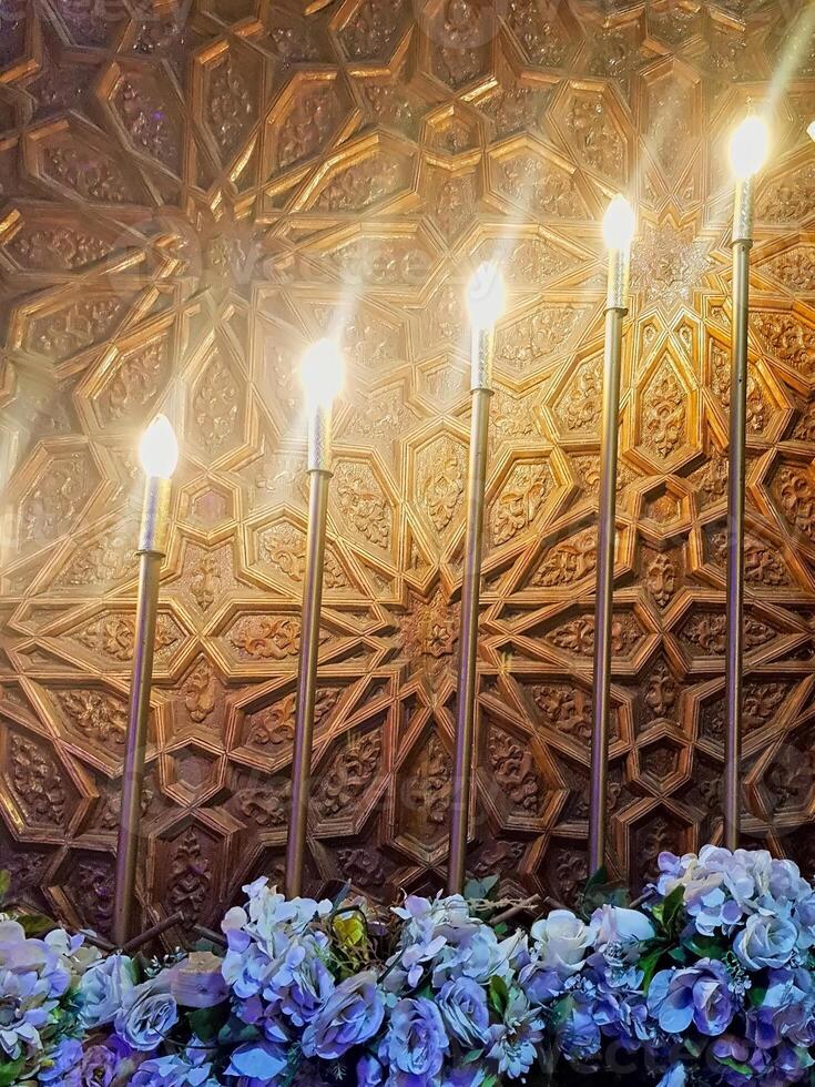 Carved wood and exquisite flowers, lights are meticulously arranged in an captivating visual display that beautifully highlights the perfect synergy between illumination and masterful craftsmanship. photo