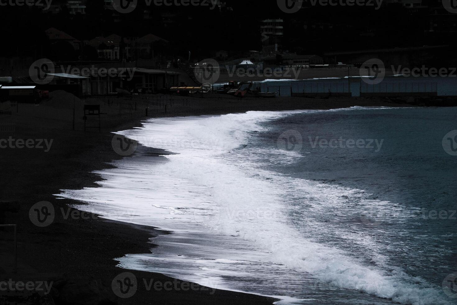 the beach with dark colors, from the white of the sea to the black of the beach photo