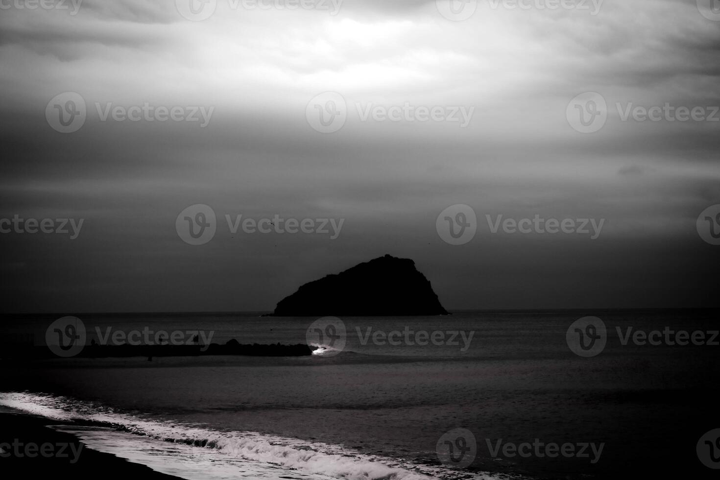 calm background of bergeggi island in black and white with silky sea water photo