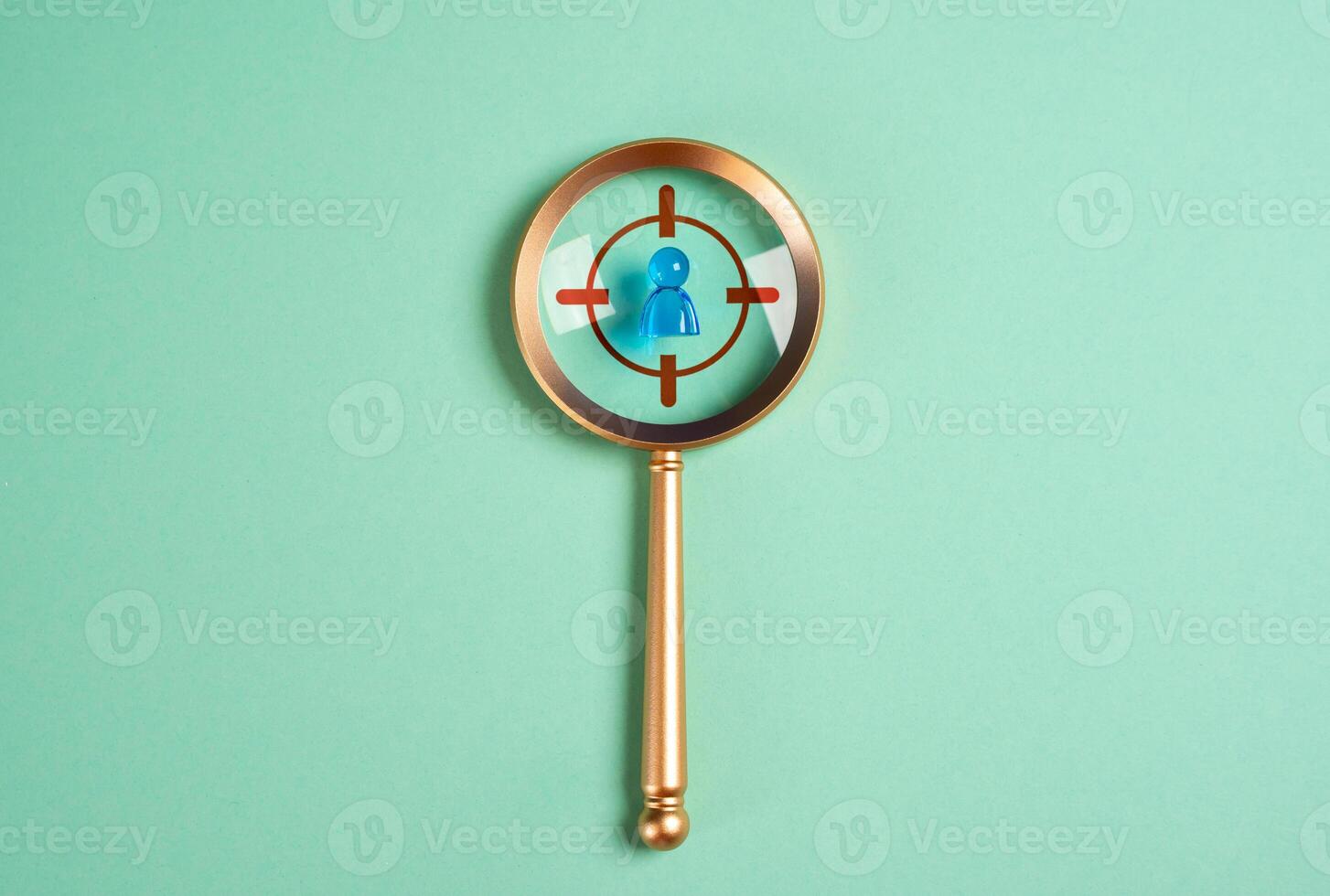 Magnifying glass and a human figure under the gun. Concept of searching and recruiting workers. Acquiring talent. Selecting top professionals under urgency. Seek ideal candidates photo