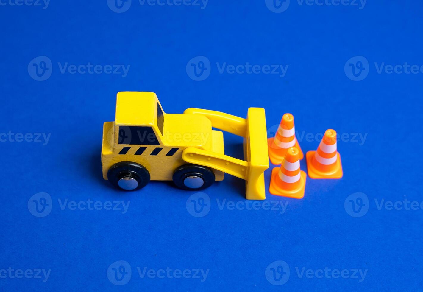 A yellow bulldozer moves traffic cones. The concept of establishing or removing restrictions. Implementing new rules. Construction zones. Policy adjustments, and public safety measures. photo