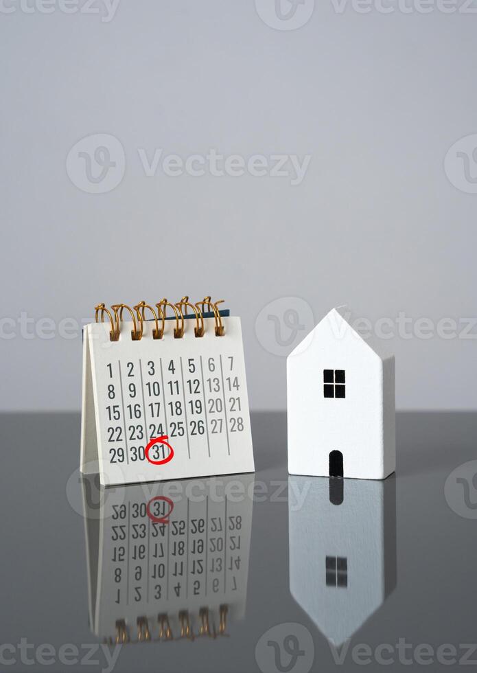House and calendar with date marked. Last day of rent payment, tenants moving out. Deadline for property taxes. Complete rent payments, finalize leases, or pay property-related taxes. Housing cycle photo
