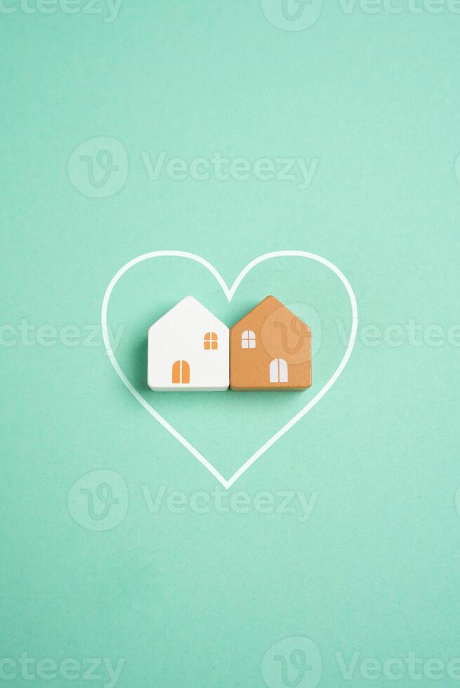 Two houses together inside the heart. Romantic relationships, starting a family. Starting a family and sharing a home reflect emotional connection. Property consolidation photo