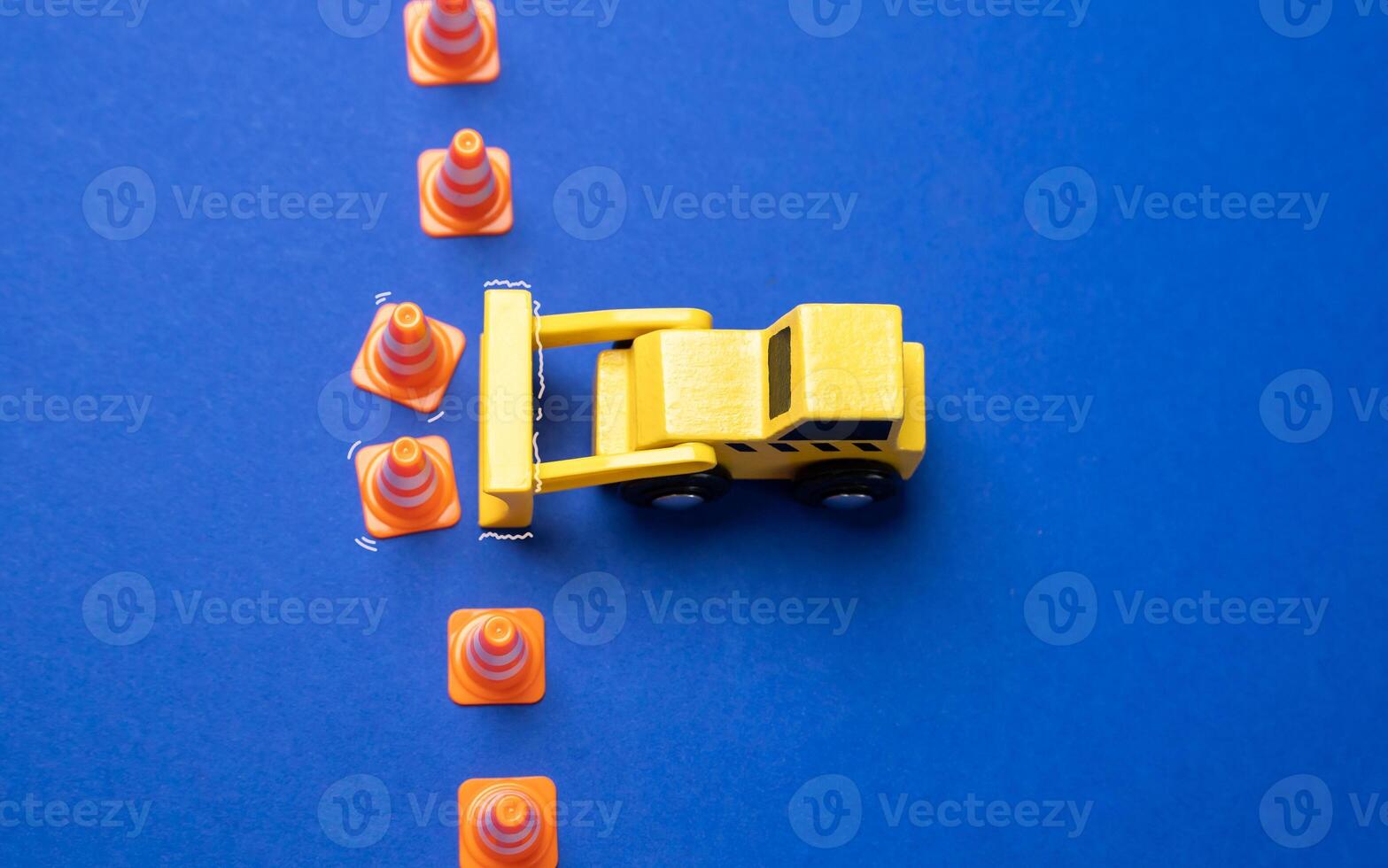 A yellow bulldozer crosses the line of cones. The concept of crossing boundaries and removing restrictions. Revision of norms and rules. Breaking through set norms, pushing past limitations photo