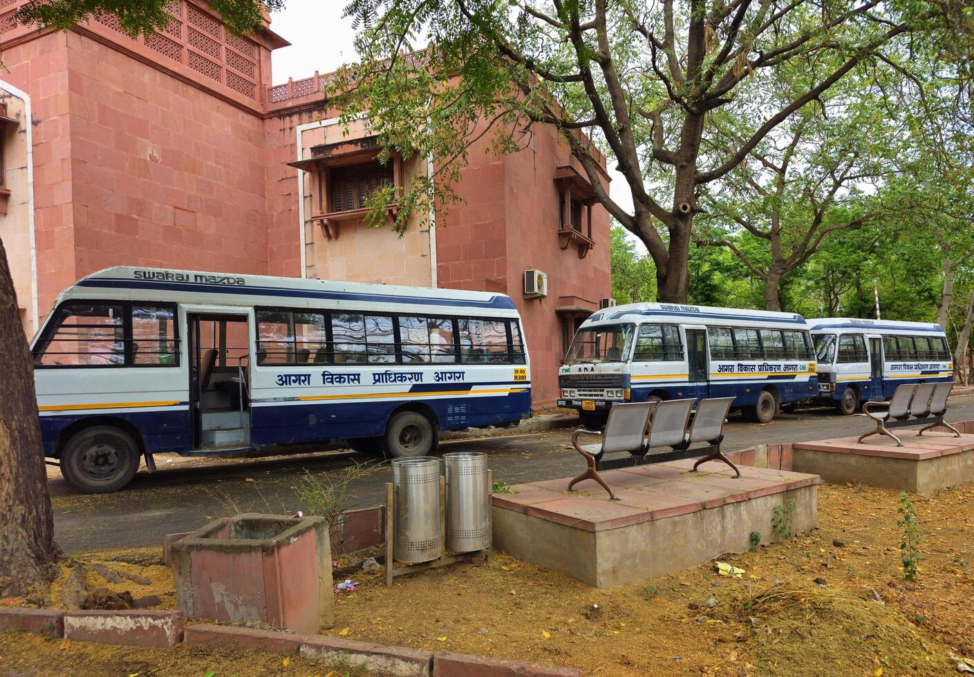 2nd May 2025 Agra India The buses are parked near a red sandstone office building, The buses have Agra Vikas Pradhikaran Agra Development Authority written on them in Hindi photo