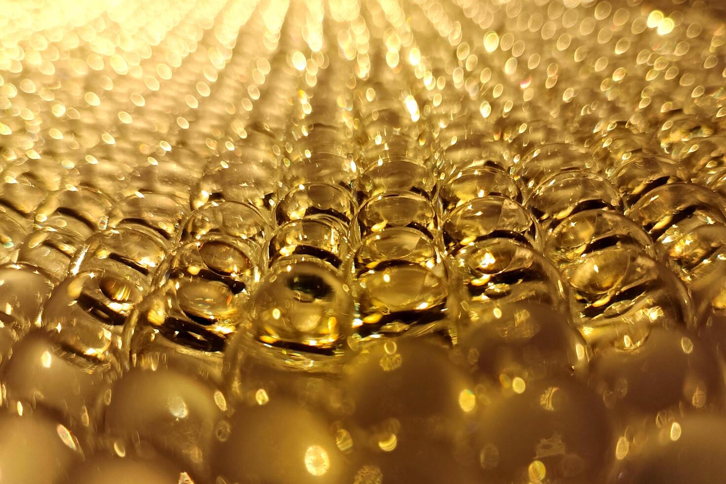 Golden bubbles shimmer under warm light, creating a mesmerizing abstract pattern. photo