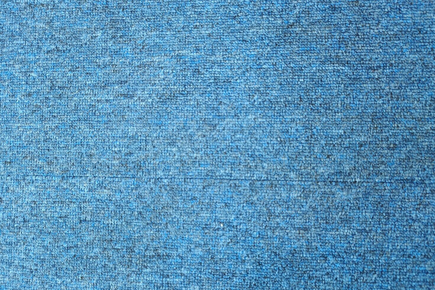 A close-up of a blue textured fabric with a subtle, speckled pattern. photo