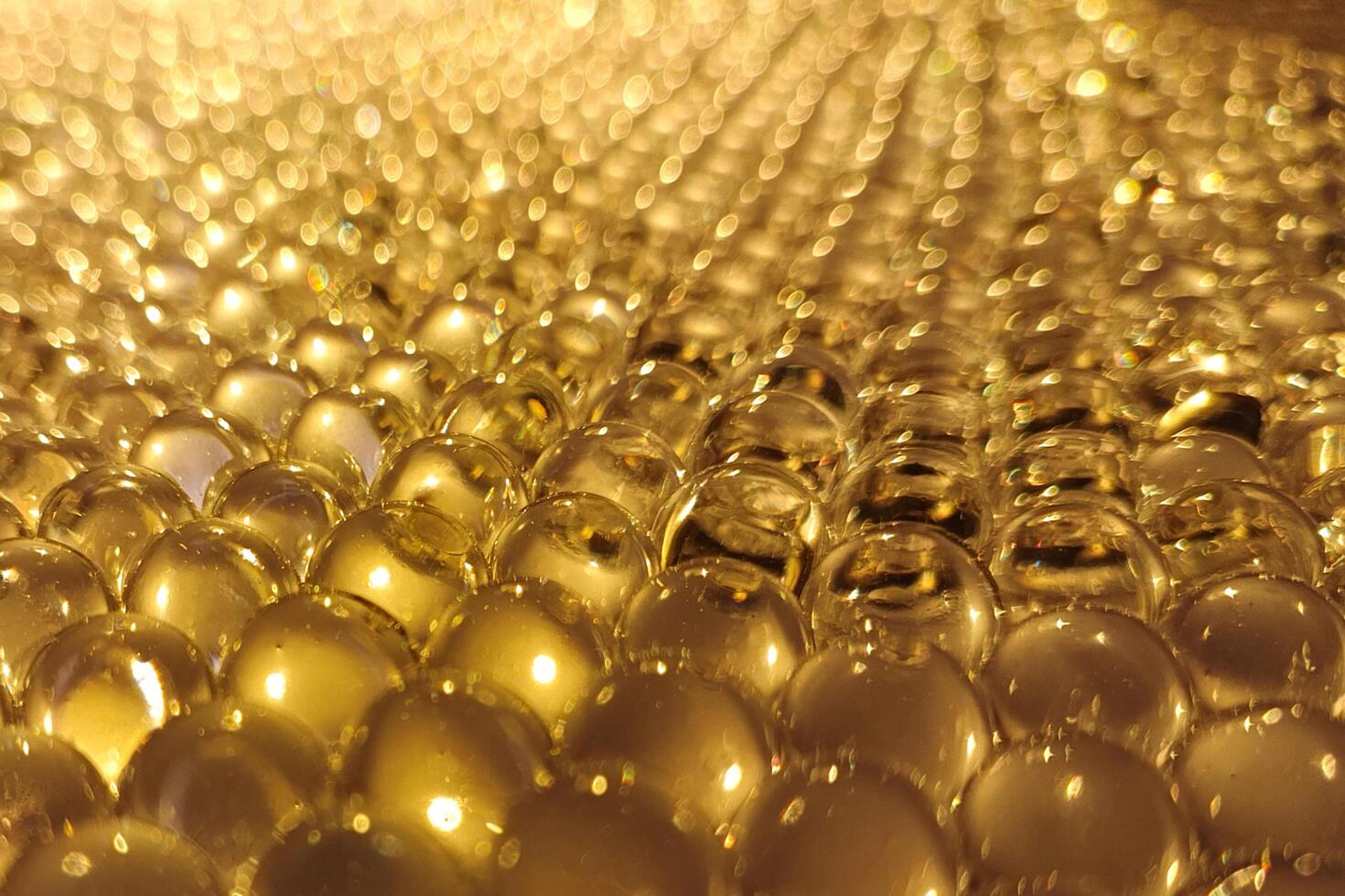Close-up of shiny golden beads with a blurred, glowing background. photo