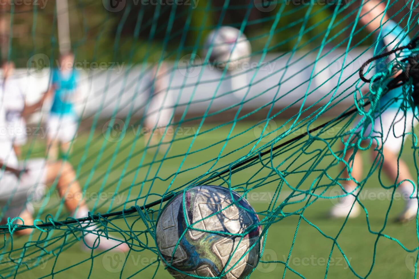 Soccer ball lies in the net on the field photo