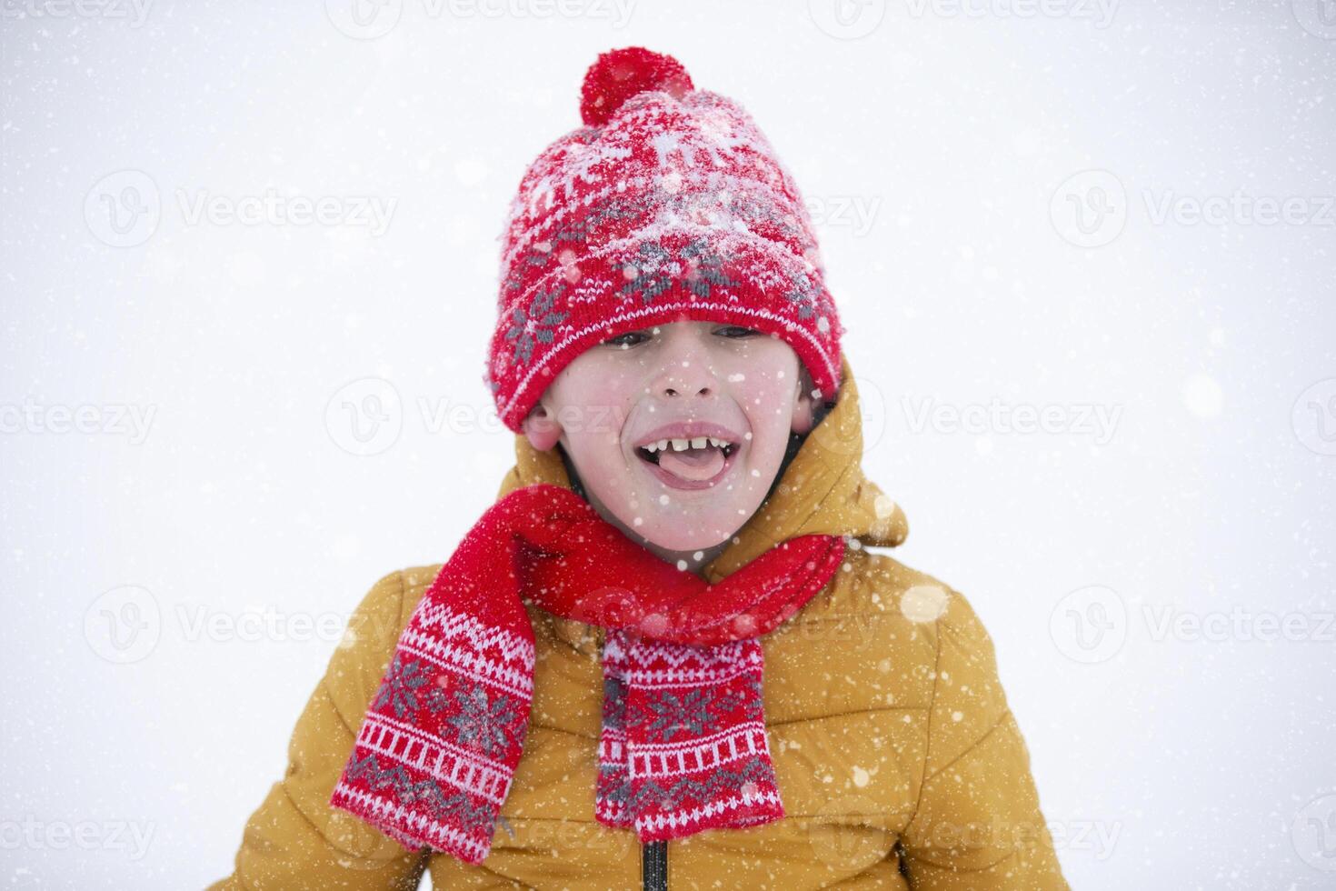 Happy little boy catches snowflakes with his tongue. Child in winter. photo